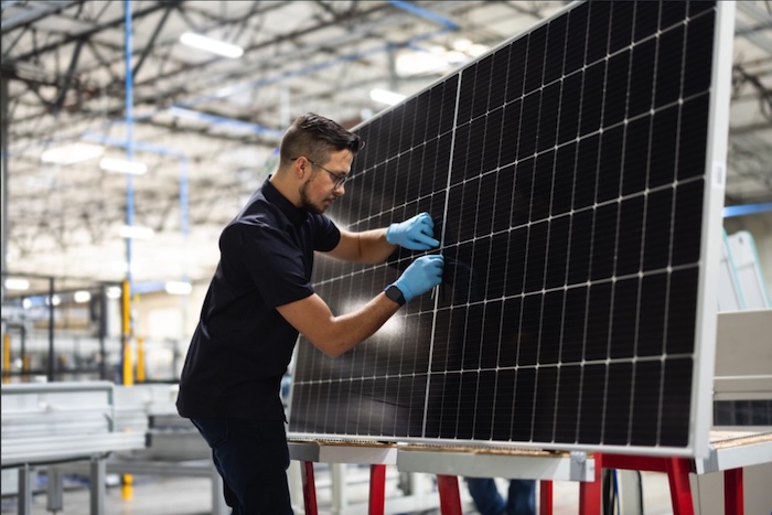 man standing next to solar panel