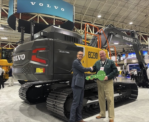 Martin Mattsson, Key Accounts Director — Waste and Recycling at Volvo CE (left), hands over the EC230 Electric keys to Harold Romberg, Director of Heavy Equipment for WM, at Waste Expo.