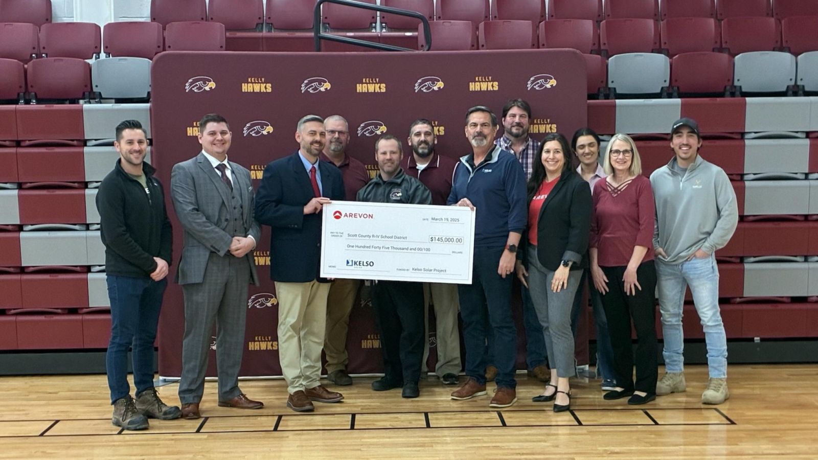 people in a gymnasium with giant check